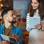 Camarera toma nota del pedido de un cliente