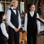 Un joven de color da una "charla" al resto del equipo de camareros de un restaurante lujoso