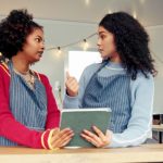 Dos jóvenes de color revisan una lista en una food truck