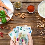 Mesa llena de alimentos y varios billetes de euros